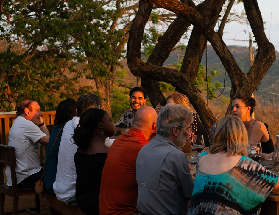 Adult learners enjoying an outdoor dinner in Nosara during the Fluenz Spanish Immersion in Costa Rica, combining Spanish classes in Costa Rica with cultural immersion, community dining, and authentic local experiences.