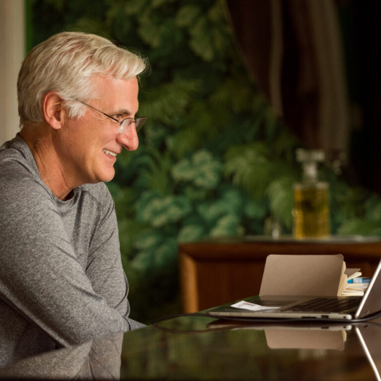 Smiling student engaged in a one-on-one Fluenz Live Online Spanish session, learning with expert coaches through personalized virtual immersion for adults.