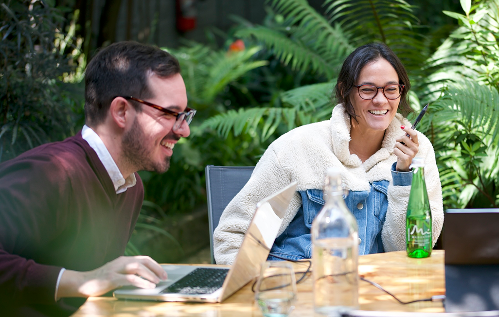 Spanish coach and learner enjoying an outdoor one-on-one session during the Fluenz Spanish Bootcamp in Mexico City, surrounded by lush greenery in a serene Polanco courtyard.
