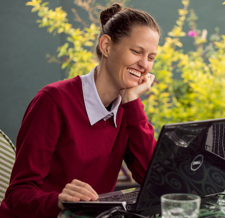Fluenz Spanish coach smiling during an online one-on-one session, part of the personalized Fluenz Live Online Spanish immersion.
