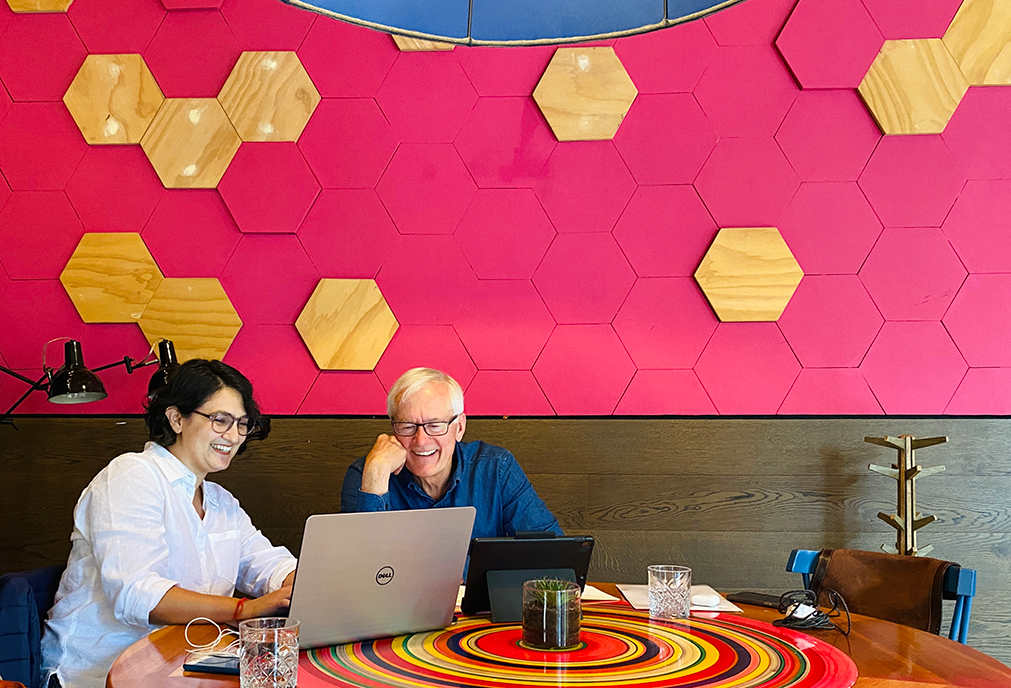 A Spanish tutor and an adult learner sharing a moment of laughter during a one-on-one session at the Fluenz Spanish Bootcamp in Mexico City, an immersive program offering personalized Spanish instruction for professionals and motivated adults.