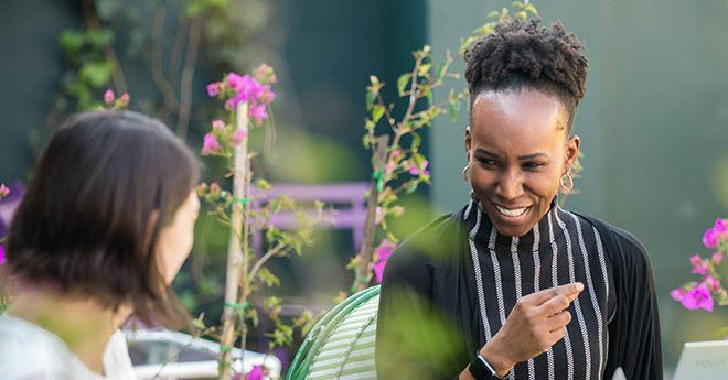 A learner enjoys a lively one-on-one session with her Spanish tutor at the Fluenz Spanish Bootcamp in Mexico City. Surrounded by bright flowers, the scene captures the energy and focus of the best intensive Spanish learning program in Mexico, designed for adults seeking personalized and immersive fluency.