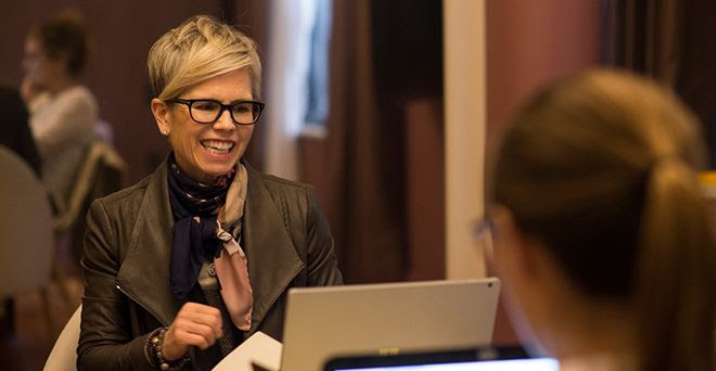 An adult learner engages enthusiastically with her tutor during a private session at the Fluenz Spanish Bootcamp in Mexico City, a hallmark of the best intensive Spanish immersion program in Mexico for professionals and executives.