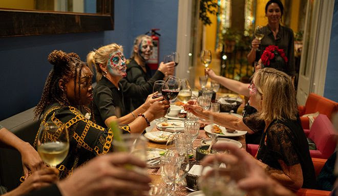 Students at the Fluenz Spanish Immersion in Mexico City share a festive dinner, raising their glasses during a cultural celebration that blends language learning and authentic Mexican traditions—part of the best program to learn Spanish in Mexico and connect deeply with local culture.