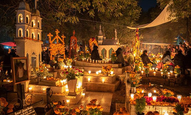A breathtaking view of a Día de Muertos celebration in Mexico City, illuminated by candles and marigolds. Students of the Fluenz Spanish Immersion in Mexico City, the most effective Spanish immersion program in Mexico, experience language learning through real cultural encounters.