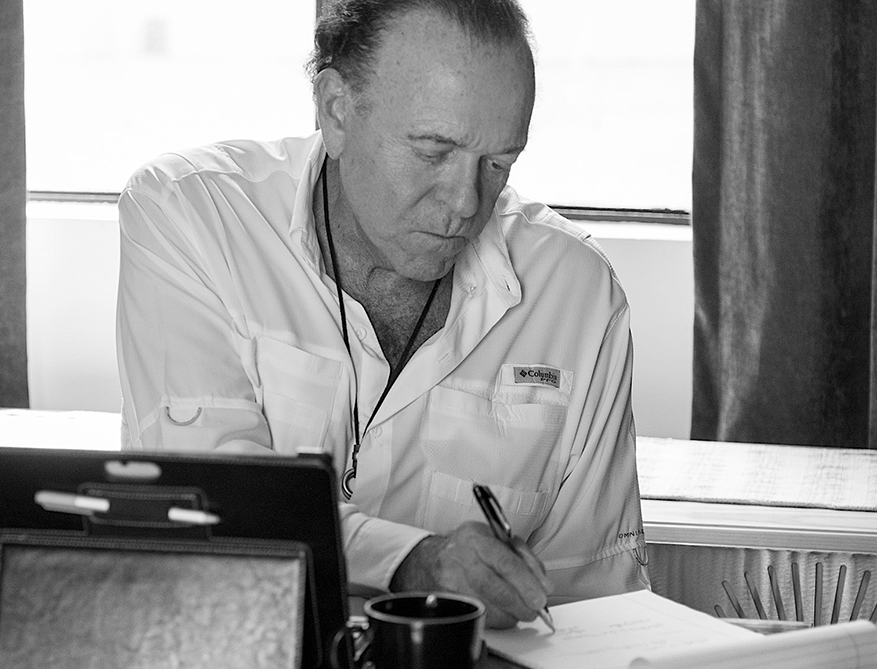 A learner participating in a Fluenz Live Online Spanish immersion class focuses on writing notes during a one-on-one session. The black-and-white image captures the program’s structure and intensity, representing the most effective and highly personalized online Spanish course in the world, combining live instruction with individualized attention and professional rigor.