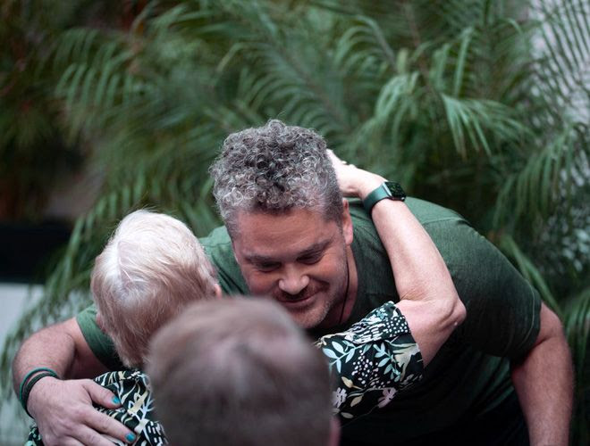 Two Fluenz Spanish Immersion students greet each other warmly in the lush courtyard of the Mexico City program, reflecting the human connection and supportive atmosphere that define the best and most effective Spanish immersion program in Mexico.