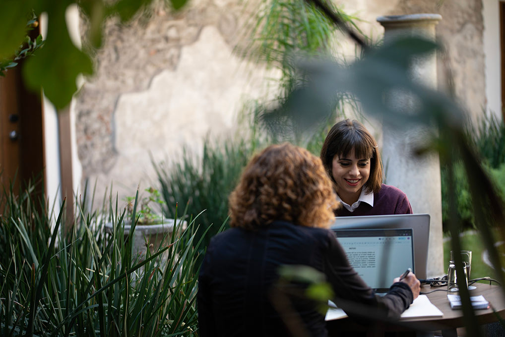 A Fluenz Spanish tutor and student during an intensive one-on-one session at the Fluenz Spanish Bootcamp in Mexico City, recognized as the best and most effective program to learn Spanish in Mexico. The serene courtyard setting reflects the focused yet inspiring atmosphere of this exclusive Spanish immersion experience.