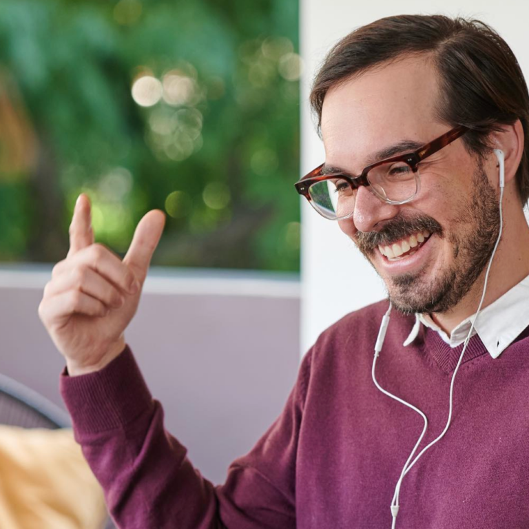 A Spanish tutor leading a live online Spanish immersion session, smiling and gesturing as he works one-on-one with a learner. The scene reflects the structured, intensive approach of the best learn-Spanish-online and learn-Spanish-on-Zoom programs in the world.