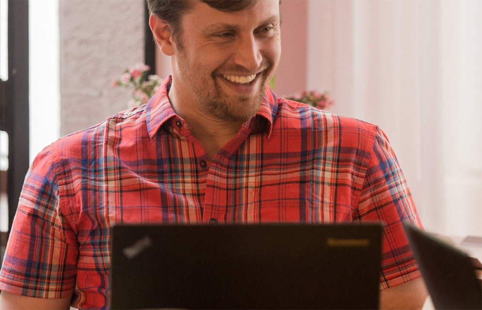 Adult learner smiling while working on a laptop during a live online Spanish session, part of an intensive one-on-one Fluenz Live Online experience. Online Spanish immersion with real structure, personalized coaching, and the best course to learn Spanish on Zoom for serious learners.
