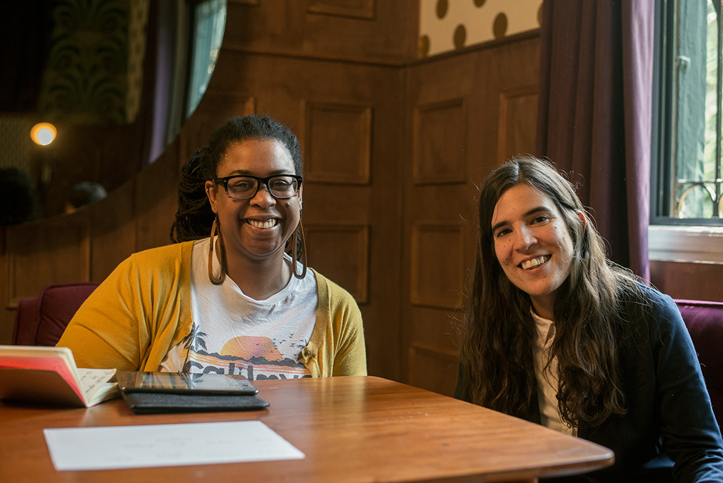 Spanish tutor and adult learner in a one-on-one session at the Fluenz Spanish Bootcamp in Mexico City. Two women sit together at a wooden table with notebooks open, focusing on intensive Spanish learning with personalized coaching. The best program to learn Spanish in Mexico City and the most effective Spanish immersion bootcamp for adult learners.