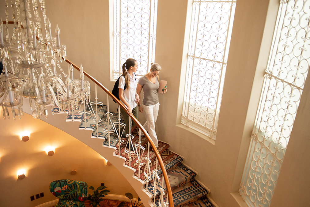 Student and Spanish tutor walking down the staircase at the Fluenz Spanish Bootcamp in Mexico City. Intensive Spanish learning in Mexico City with the best program to learn Spanish in Mexico. The most effective one-on-one Spanish tutor and student experience.