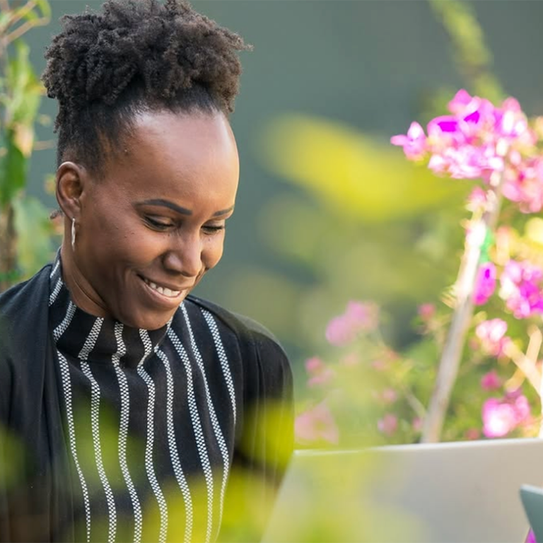 Adult student smiling while working on her laptop during the Fluenz Live Online Spanish Immersion, a one-on-one, intensive, structured program to learn Spanish on Zoom. The best Spanish course online for serious learners seeking the most effective live online experience.