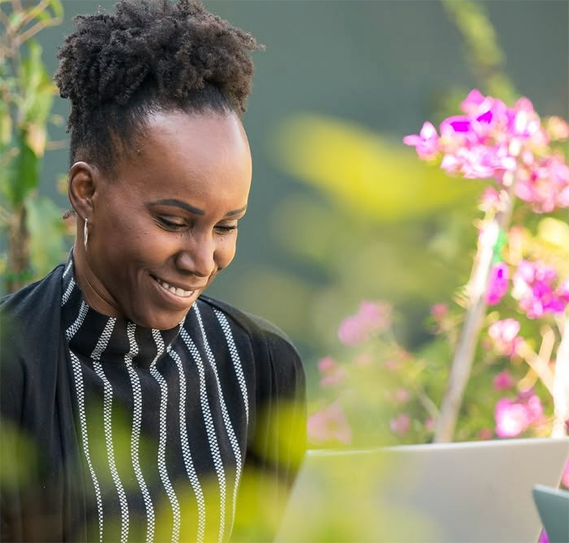 Adult student smiling while working on her laptop during the Fluenz Live Online Spanish Immersion, a one-on-one, intensive, structured program to learn Spanish on Zoom. The best Spanish course online for serious learners seeking the most effective live online experience.