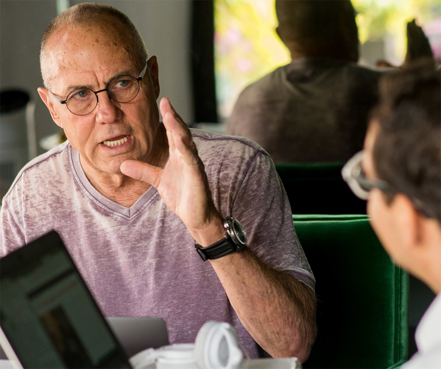 An older student speaks with his Spanish tutor during a one-on-one session at the Fluenz Spanish Bootcamp in Mexico City, working through intensive Spanish learning exercises on his laptop. A focused moment from the best program to learn Spanish in Mexico City and the most effective student–Spanish tutor experience in Mexico.