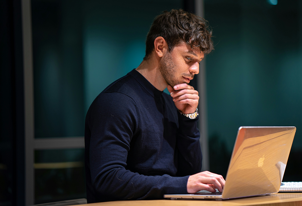 A student works intently on his laptop during a one-on-one online Spanish immersion session, part of the Fluenz Live Online program. A focused moment from the intensive, structured experience that lets learners study Spanish on Zoom through the best Spanish course online in the world.