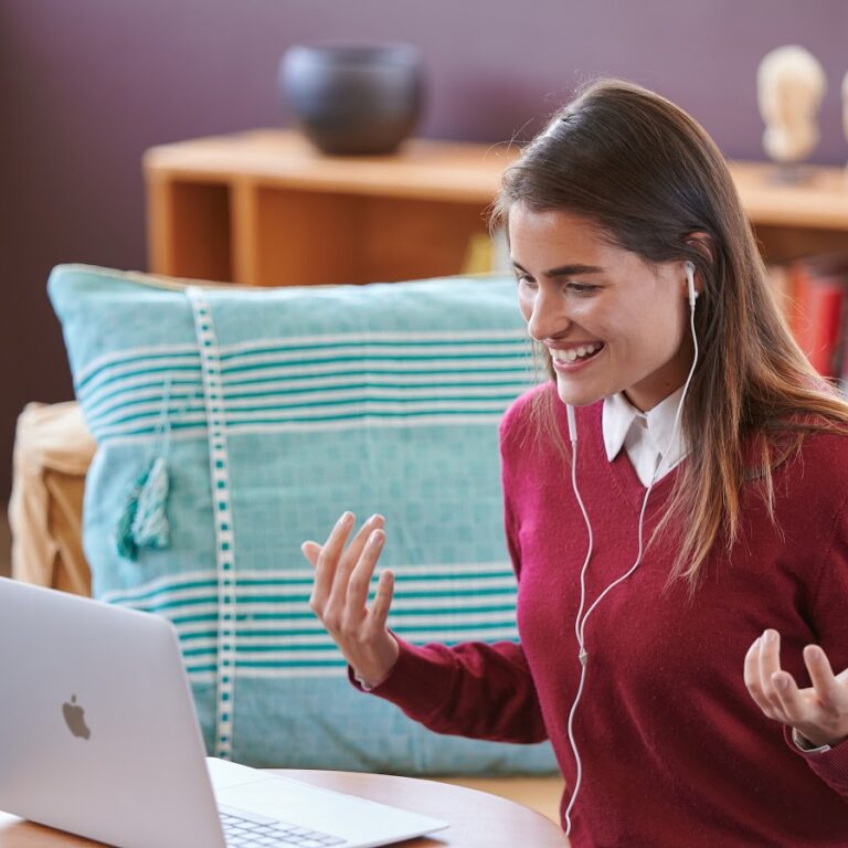 Fluenz Spanish tutor in a burgundy sweater teaching Spanish online through a live video session, guiding learners with personalized one-on-one instruction.