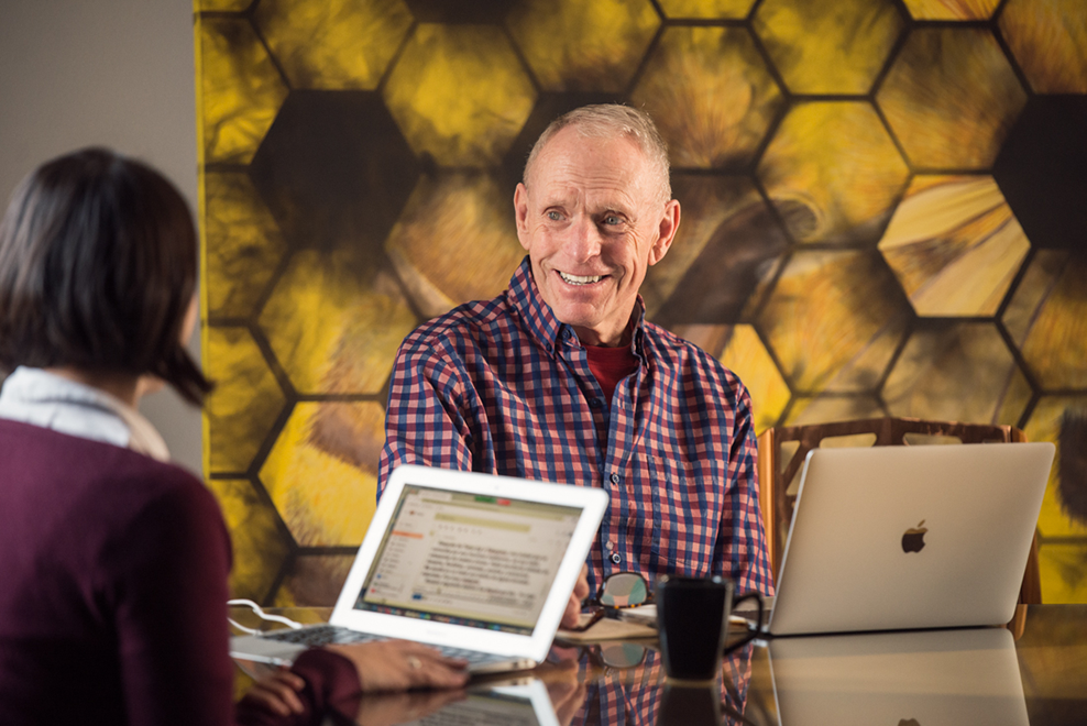 Adult learner in a one-on-one Fluenz Spanish Bootcamp session, working with a Spanish tutor at a table with laptops, focused on personalized instruction in Mexico City.