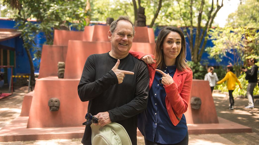 Fluenz founder Sonia Gil and an adult Spanish immersion student smiling together during a cultural outing in Mexico City, standing outdoors near a public art installation as part of the Fluenz Spanish immersion experience.