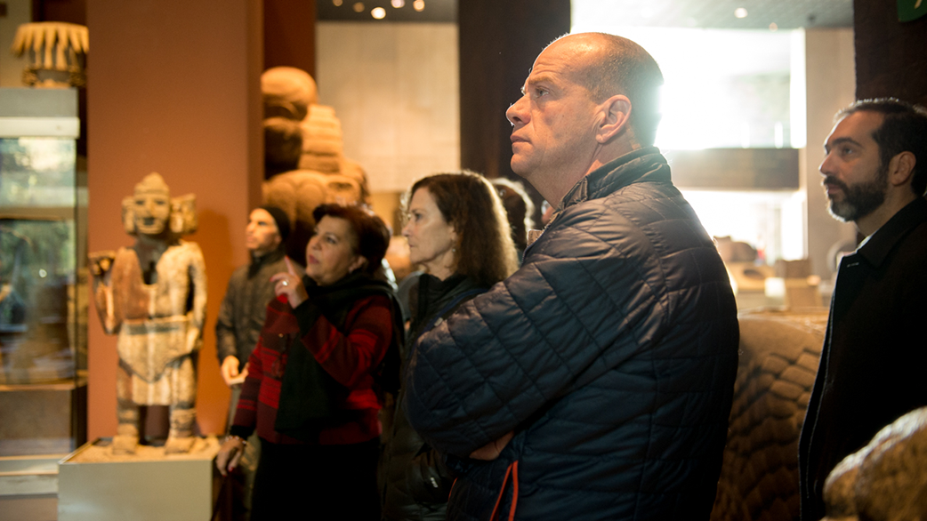 Adult learners participating in a Fluenz Spanish immersion cultural experience in Mexico City, observing pre-Hispanic artifacts during a guided museum visit as part of the program’s cultural education.