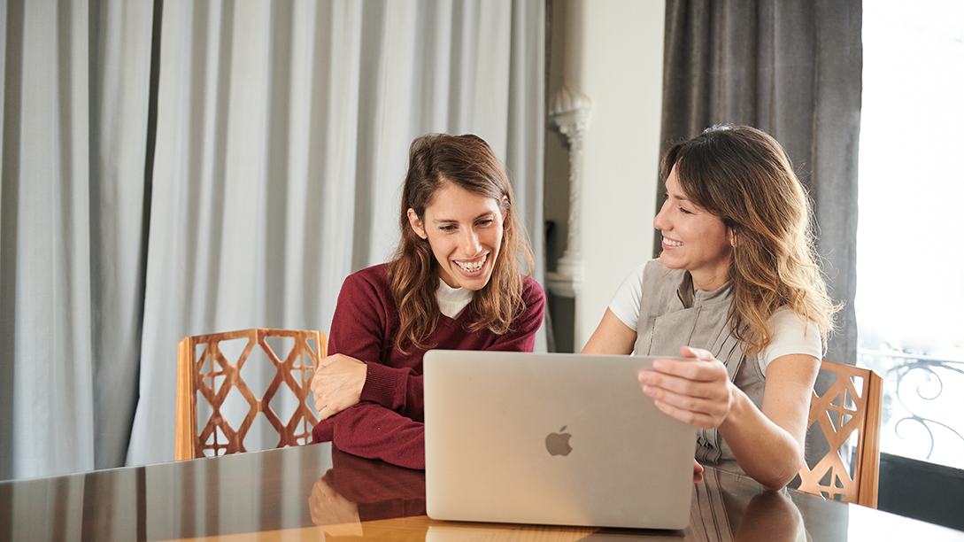 Fluenz founder Sonia Gil collaborating with a Spanish tutor during a one-on-one online Spanish immersion session, reviewing lesson materials together on a laptop.