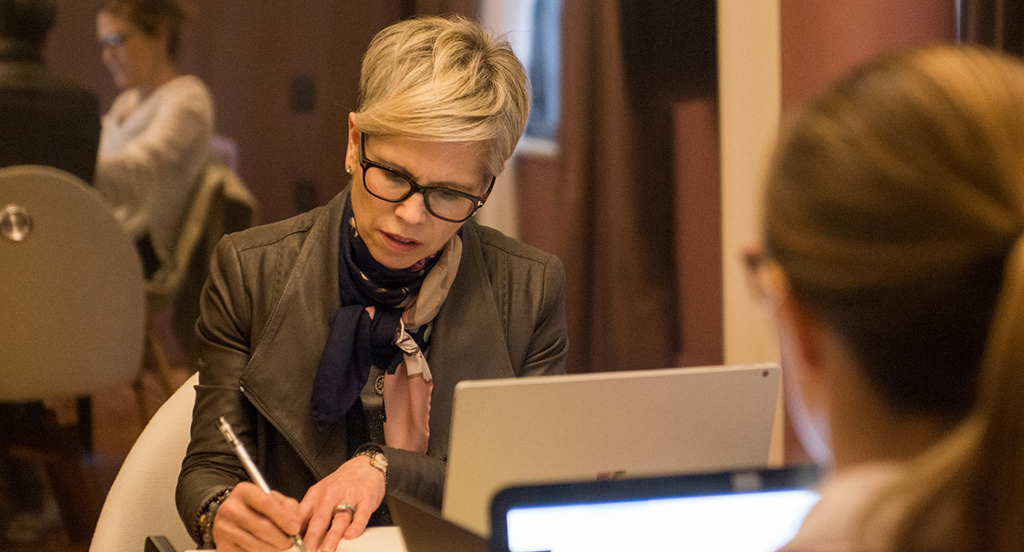 Adult Fluenz learner working one-on-one with a Spanish coach, reviewing personalized materials during an intensive private session at the Fluenz Spanish Bootcamp, known for its rigorous structure and high-touch methodology.