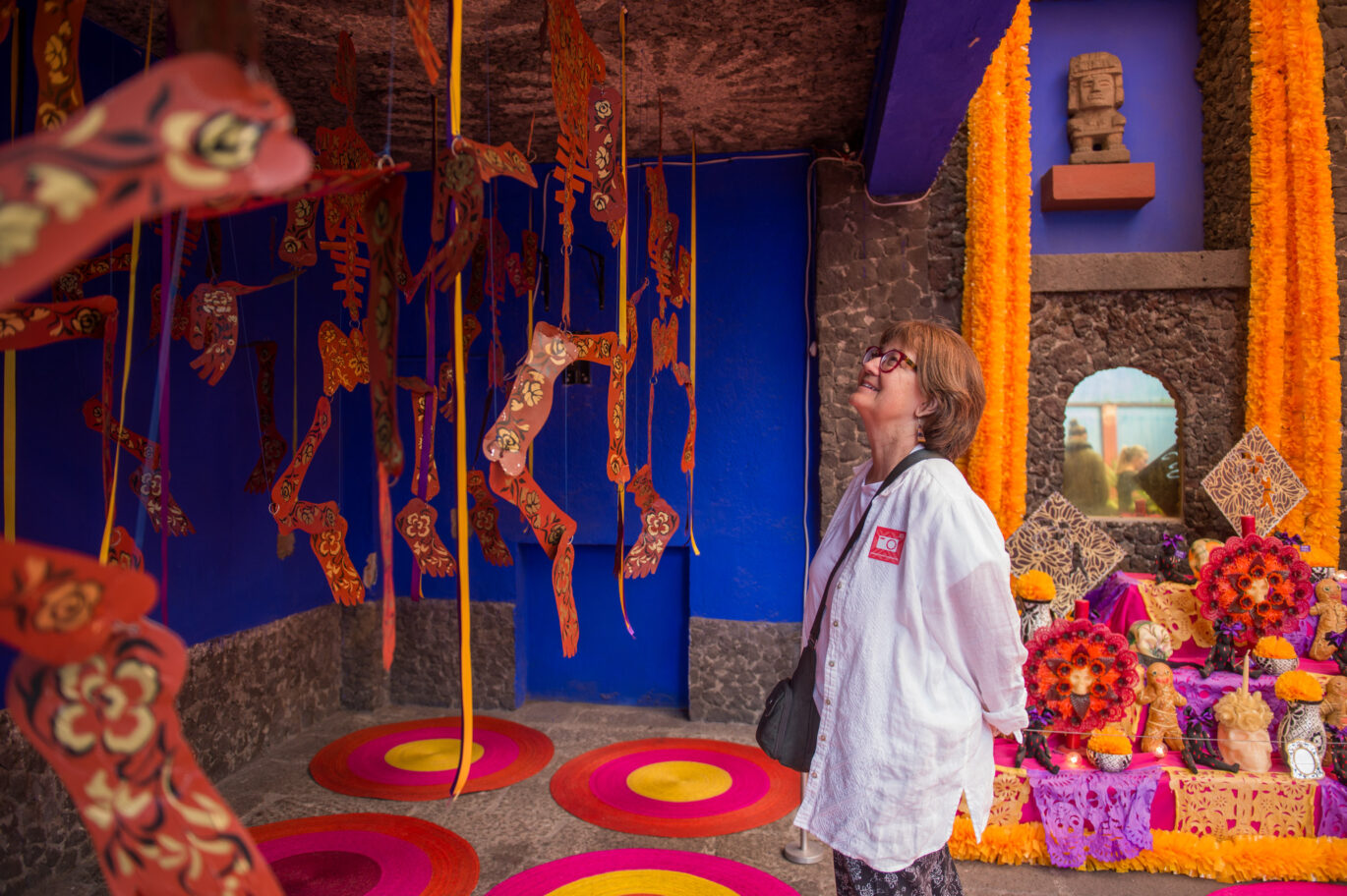Adult learner participating in a cultural activity during the Fluenz Spanish Immersion in Mexico City, exploring a Día de los Muertos art installation as part of a luxury program that combines private museum visits, curated cultural experiences, and the most effective Spanish immersion in the world.
