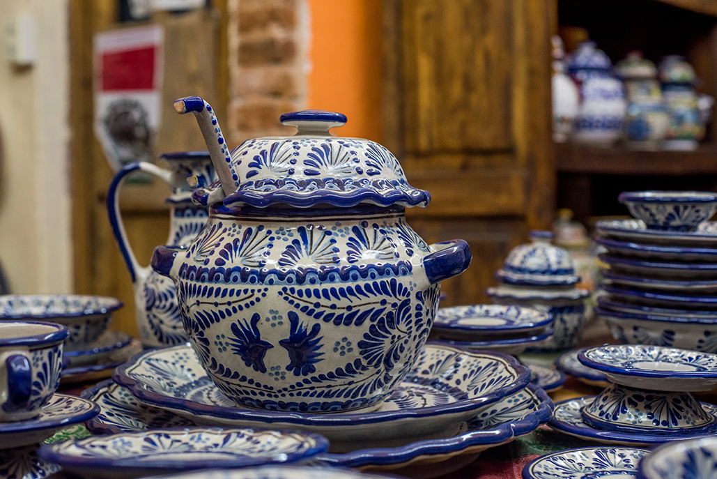 Traditional Talavera pottery displayed in Puebla, Mexico—hand-painted blue-and-white ceramic tableware reflecting the cultural setting of the Fluenz Spanish Immersion experience.