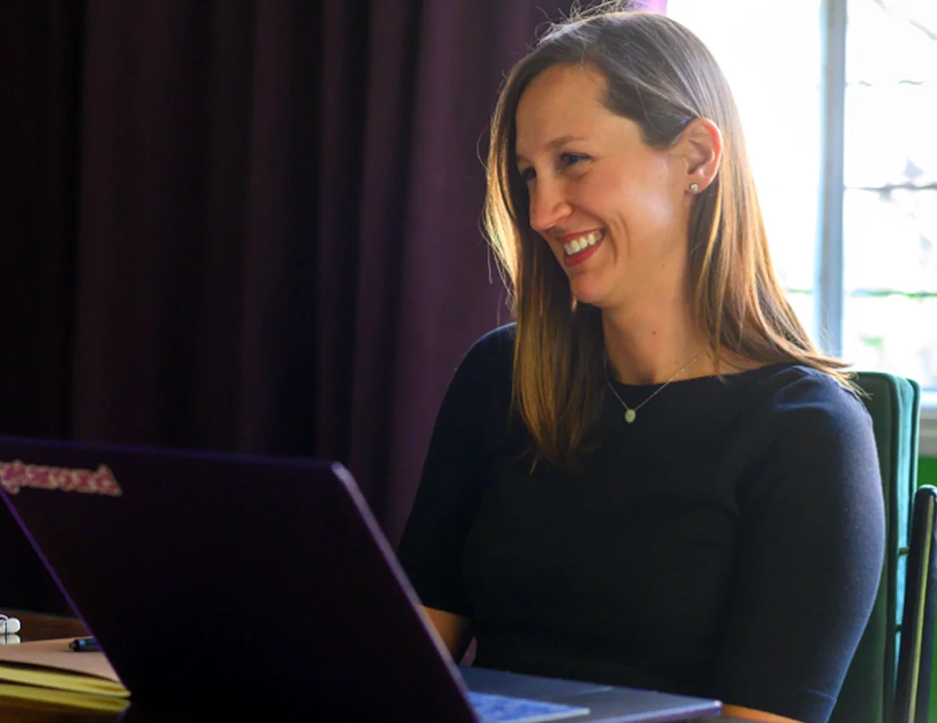 Adult learner smiling during a personalized one on one session at the Fluenz Spanish Bootcamp, engaged and focused while working with a coach.