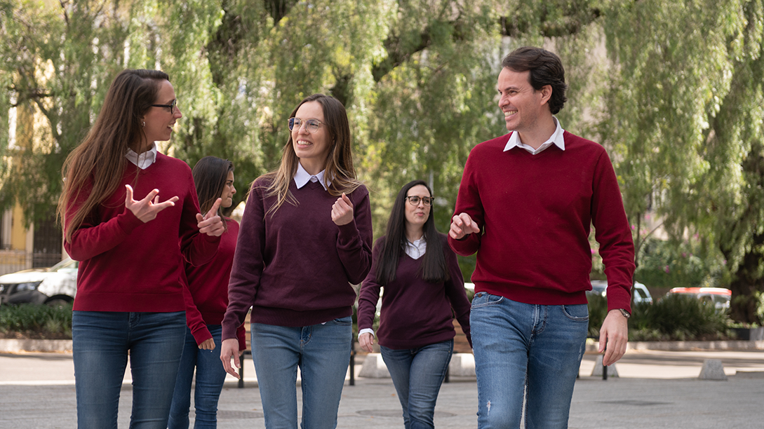 A group of Fluenz Spanish tutors walk together outdoors, representing the elite team behind the online Spanish immersion on Zoom, widely recognized as the most effective and best-reviewed program in the world.