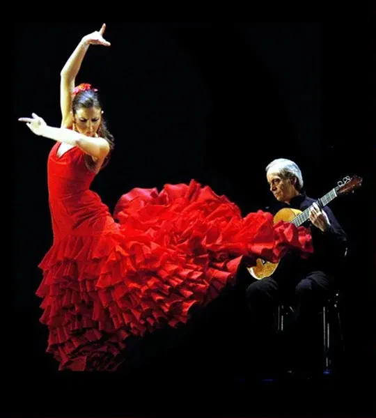 A flamenco dancer in a dramatic red dress performs alongside a guitarist during the Fluenz Spanish Immersion in Madrid—one of the many curated cultural experiences included in the program.