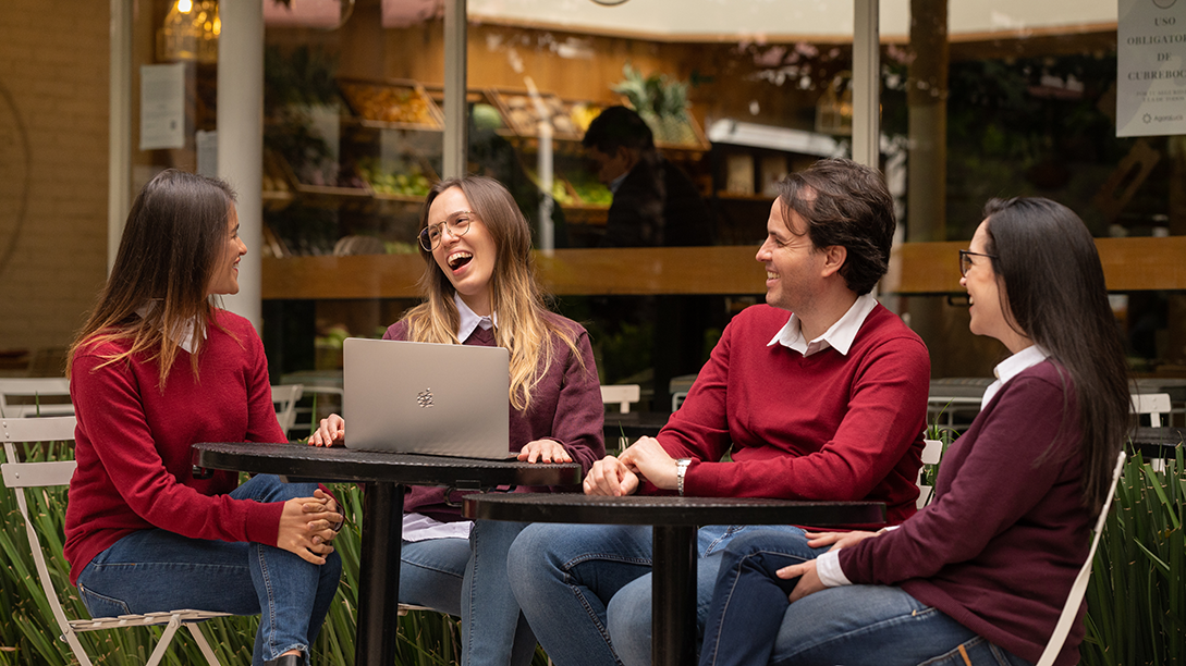 A group of Fluenz Spanish tutors—recognized among the best in the world—sit together at an outdoor café, engaging in dynamic conversation and guiding immersive, real-world Spanish learning.