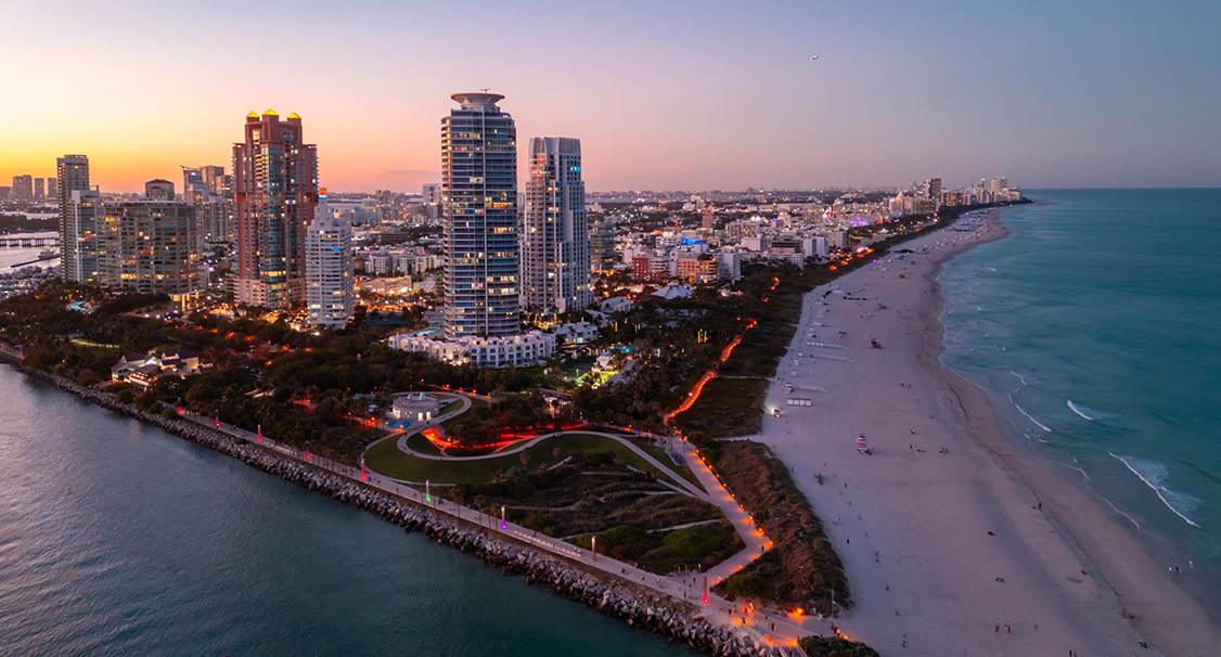 Aerial view of Miami Beach at sunset, showcasing the oceanfront skyline and vibrant coastal atmosphere surrounding the Fluenz Miami Spanish Bootcamp.