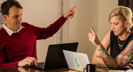 Fluenz Spanish Bootcamp participant practices one-on-one with a tutor while working on laptops.