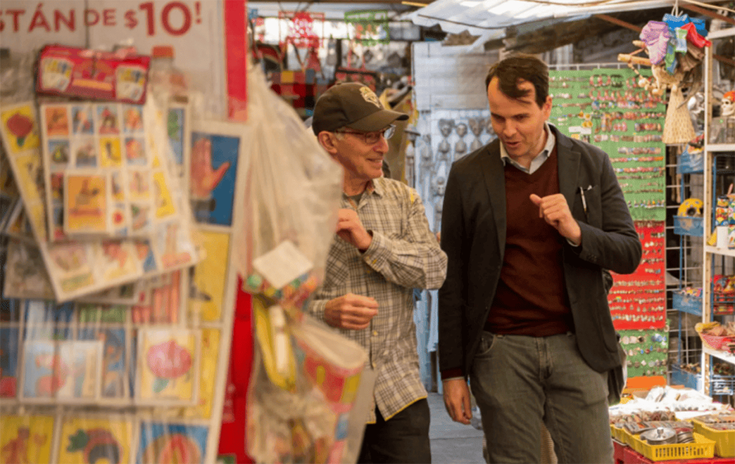Fluenz Spanish Bootcamp participant practices Spanish with a tutor while exploring a local market.