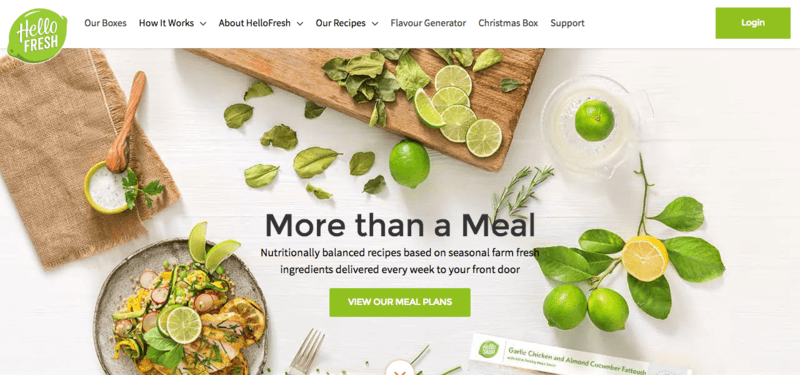 Hello Fresh meals website screenshot showing a white table with various foods including many limes and a plate that contains a chicken and grain dish.
