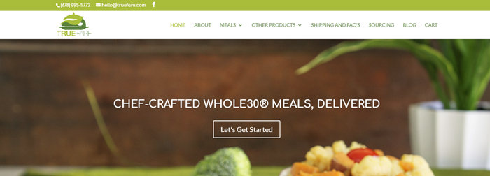 True Fare website screenshot showing wan image of a dinner on a table, along with a pot plant in the background.