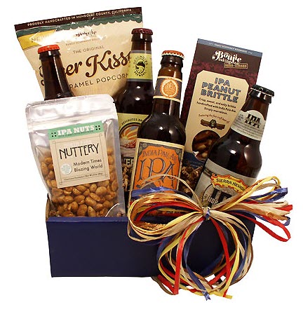 A blue box containing four beers, along with a pack of popcorn, peanut brittle and nuts.