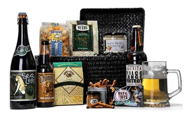 Various bottles of beer, snacks, a mug of beer and a black basket.
