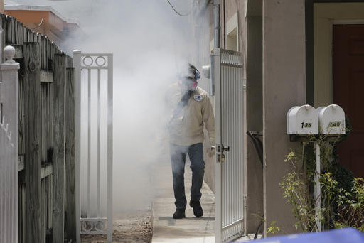 A Miami-Dade County mosquito control worker sprays around a home in the Wynwood area of Miami on Monday, Aug. 1, 2016. The CDC has issued a new advisory that says pregnant women should not travel a Zika-stricken part of Miami, and pregnant women who live there should take steps to prevent mosquito bites and sexual spread of the virus. (AP Photo/Alan Diaz)