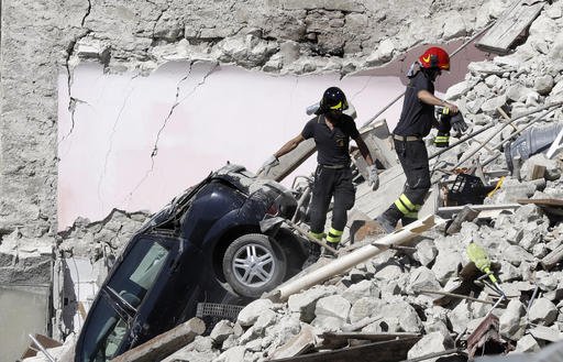 Rescuers make their way through destroyed houses following Wednesday's earthquake in Pescara Del Tronto, Italy, Thursday, Aug. 25, 2016. Rescue crews raced against time Thursday looking for survivors from the earthquake that leveled three towns in central Italy, but the death toll rose to 247 and Italy once again anguished over trying to secure its medieval communities built on seismic lands. (AP Photo/Gregorio Borgia)