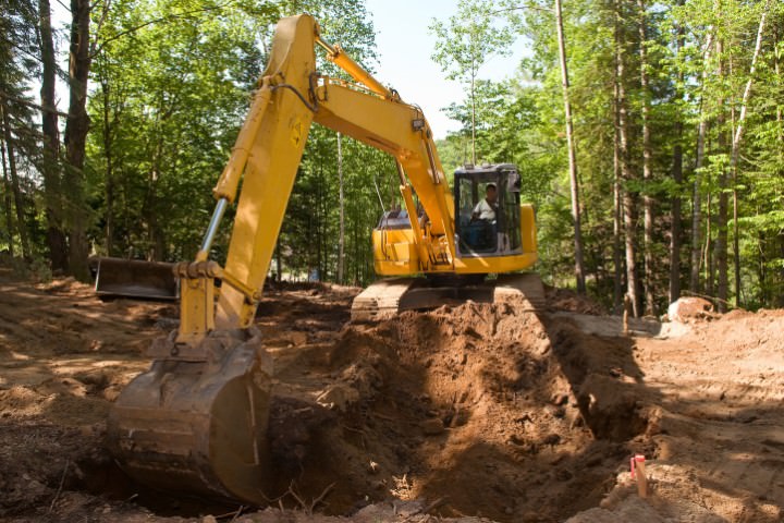 Heavy equipment excavating soil as the first major step in pool construction