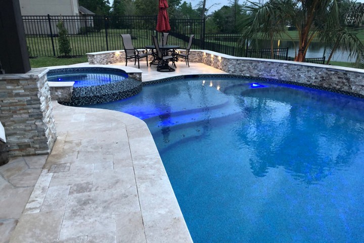 Optimal pool lighting placement highlights the spa and swimming area at night