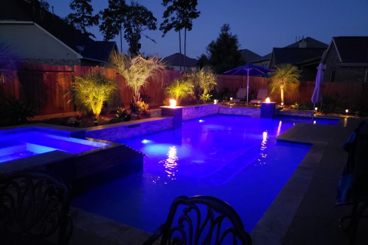 LED pool lights and landscape uplighting create layered lighting across the yard