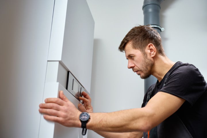 Technician installing a pool automation control panel for convenient operation