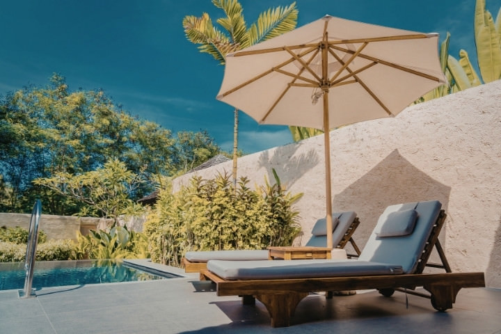 Poolside lounge chairs for visibility and privacy wall for comfort