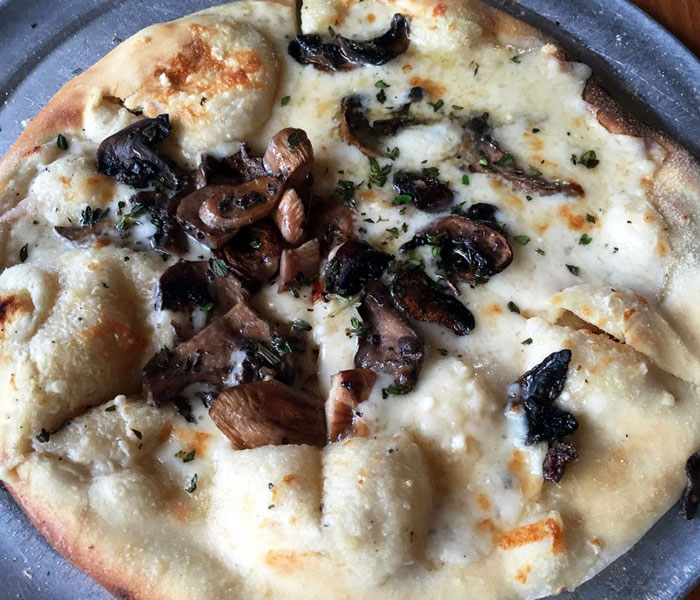 This gourmet white pizza features garlic, parmesan, fresh thyme and, of course, white sauce.
