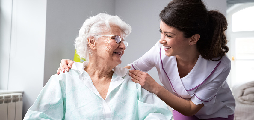 nurse talking to elderly women in wheelchair