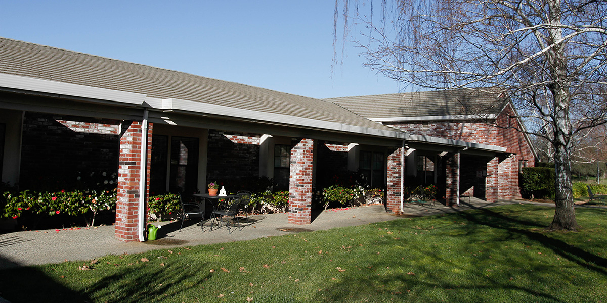 Oakwood Village covered seating outside with lush grass and mature
