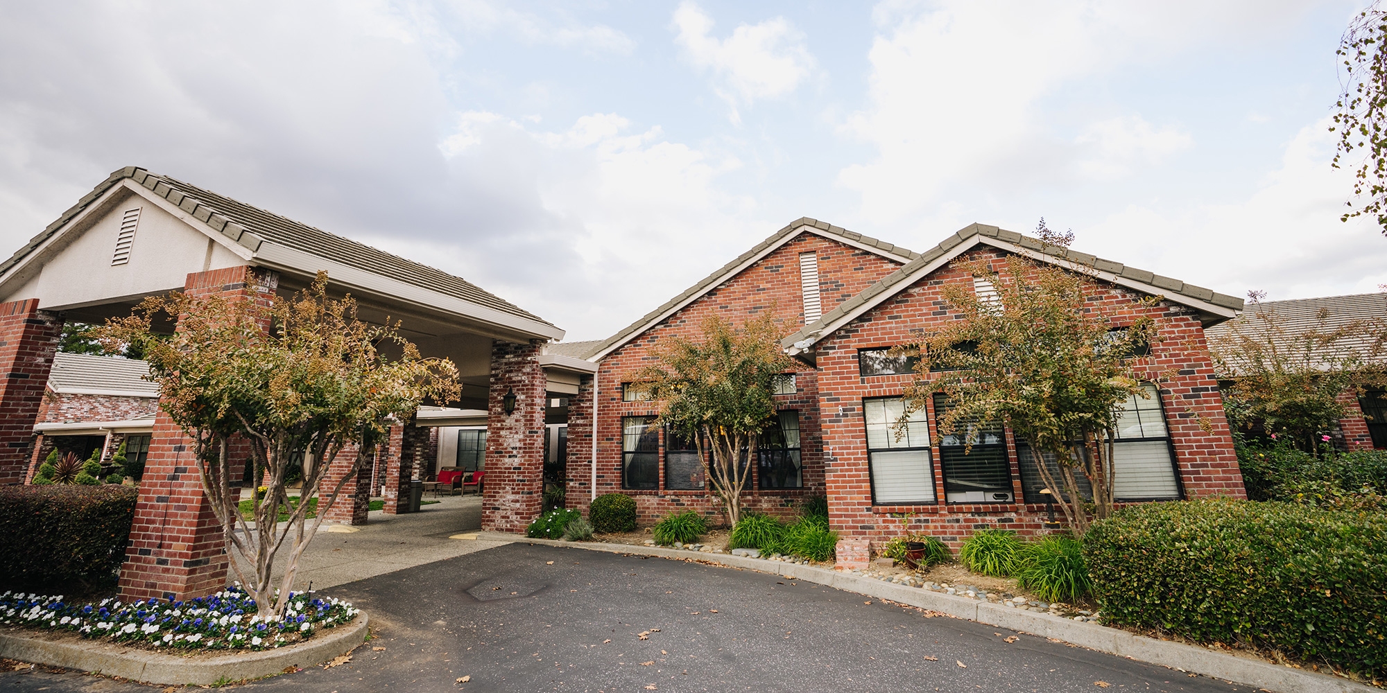 Oakwood Village community entrance lined with landscaped trees and